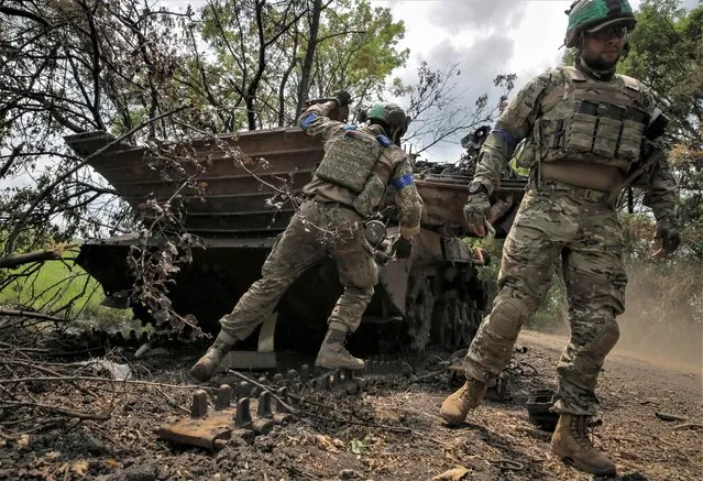 Ukrainian service members check a destroyed Russian a BMP-2 infantry fighting vehicle near the front line in the newly liberated village Storozheve in Donetsk region, Ukraine on June 14, 2023. (Photo by Oleksandr Ratushniak/Reuters)