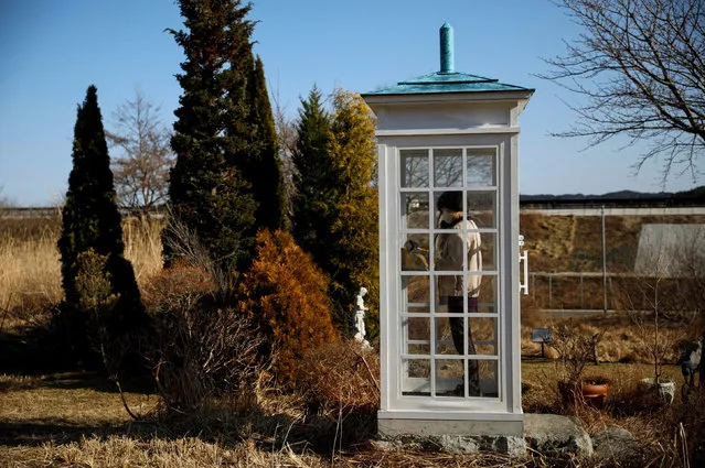 A woman from Ofunato who lost her junior high school classmates in the March 11, 2011 earthquake and tsunami, calls her late friends inside Kaze-no-Denwa (the phone of the wind), a phone booth set up for people to call their deceased loved ones, at Bell Gardia Kujira-yama, ahead of the 10th anniversary of the disaster, in Otsuchi town, Iwate Prefecture, northern Japan on February 28, 2021. (Photo by Issei Kato/Reuters)