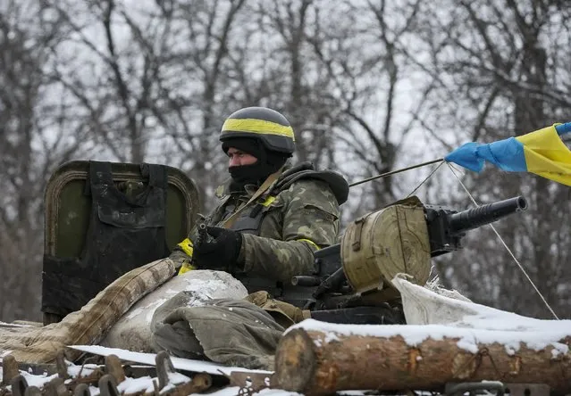 A member of the Ukrainian armed forces rides on an armoured personnel carrier (APC) near Debaltseve, eastern Ukraine, February 10, 2015. Ukrainian President Petro Poroshenko said peace talks in Minsk on Wednesday were one of the last chances to declare an unconditional ceasefire in the conflict with Russia-backed separatists, a statement on his website said on Tuesday. (Photo by Gleb Garanich/Reuters)