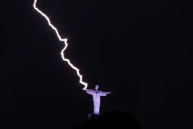 A lightning hits the hand of the Christ the Redeemer statue at the Corcovado mountain in Rio de Janeiro, Brazil, on February 21, 2023. (Photo by Mauro Pimentel/AFP Phoot)