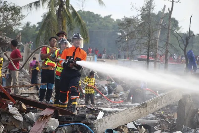 A fireman sprays water after an explosion occured at a firework warehouse in Narathiwat province southern Thailand, Saturday, July 29, 2023. A large explosion at a fireworks warehouse in southern Thailand on Saturday killed at least nine people and wounded scores, officials said. (Photo y Kriya Tehtani/AP Photo)