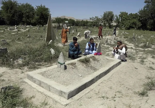Abdul Rauf right, prays over the grave of his daughter Shahnaz Raufi, a worker at a TV station who was killed in a March attack claimed by the Islamic State group, in Jalalabad, Afghanistan, Wednesday, April 21, 2021. IS has resumed a campaign of targeted killings of minority Shiite Muslims, many of them ethnic Hazaras, as well as women's rights activists and media workers. (Photo by Rahmat Gul/AP Photo)