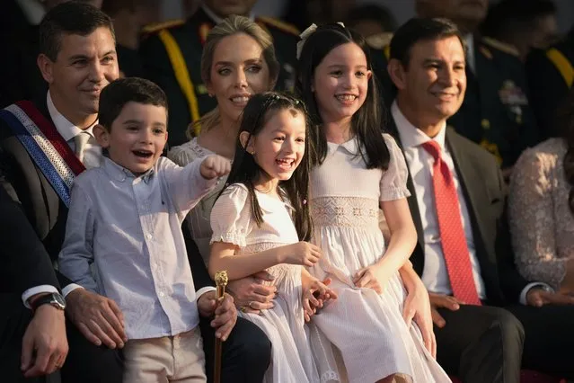Paraguay's New President Santiago Pena, left, and First Lady Leticia Ocampos, center back, attend a military parade with the company of their nephew and nieces, during his inauguration in Asuncion, Paraguay, Tuesday, August 15, 2023. (Photo by Jorge Saenz/AP Photo)