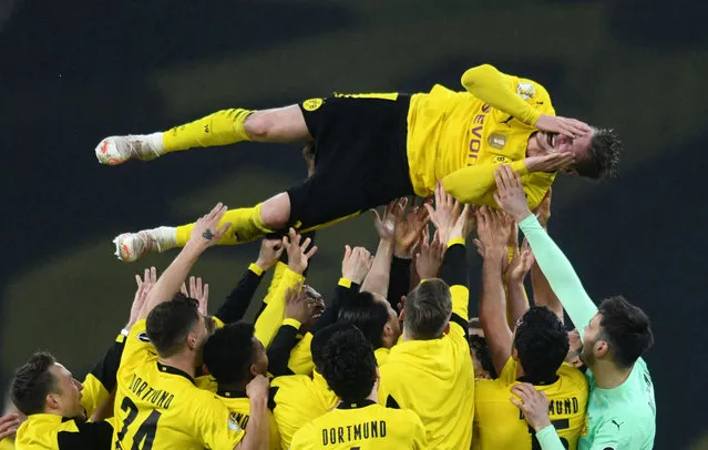 Lukasz Piszczek of Borussia Dortmund is celebrated by the players after the victory the DFB Cup final match between RB Leipzig and Borussia Dortmund at Olympic Stadium on May 13, 2021 in Berlin, Germany. Sporting stadiums around Germany remain under strict restrictions due to the Coronavirus Pandemic as Government social distancing laws prohibit fans inside venues resulting in games being played behind closed doors. (Photo by Annegret Hilse/Reuters)