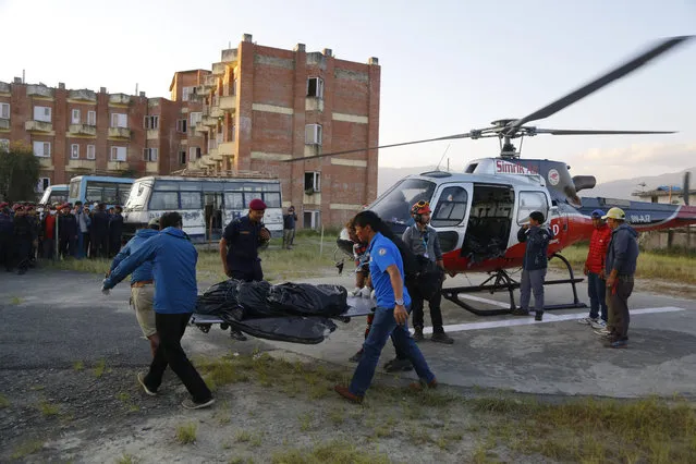Officials unload the bodies after a helicopter carrying bodies of those killed in Gurja Himal mountain arrives at the Teaching hospital in Kathmandu, Nepal, Sunday, October 14, 2018. (Photo by Niranjan Shrestha/AP Photo)