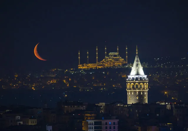 Crescent moon appears over Camlica Mosque and Galata Tower in Istanbul, Turkey on June 06, 2021. (Photo by Isa Terli/Anadolu Agency via Getty Images)