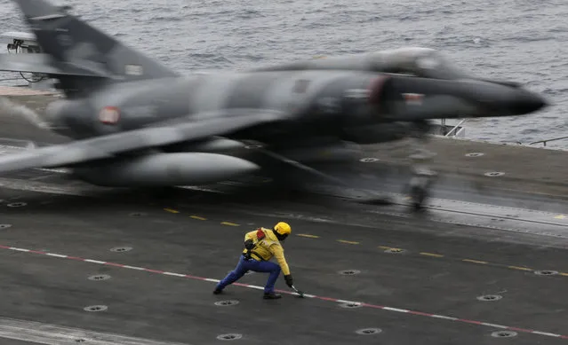 In this Tuesday, March 17, 2015 photo, a French military plane takes off from the flight deck of the French Navy aircraft carrier Charles de Gaulle in the Persian Gulf. Aircraft aboard the French carrier are flying bombing and reconnaissance missions as part of a U.S.-led coalition targeting Islamic State militants in Iraq. (Photo by Hasan Jamali/AP Photo)