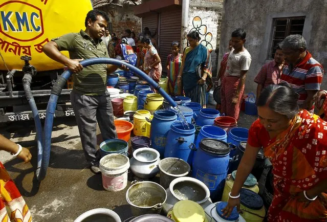 A resident fills drinking water in containers from a municipal water tanker at a slum in Kolkata March 22, 2015. (Photo by Rupak de Chowdhuri/Reuters)