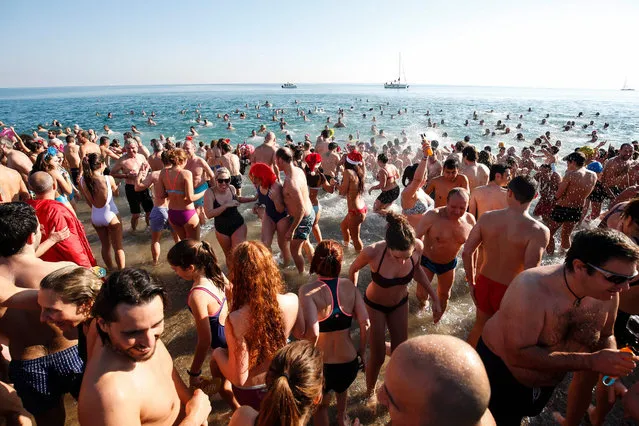 Swimmers participate in the traditional New Year day swim as part of the celebrations of the New Year at the Sant Sebastia beach in Barceloneta neighbourhood in Barcelona on January 1, 2017. (Photo by Pau Barrena/AFP Photo)