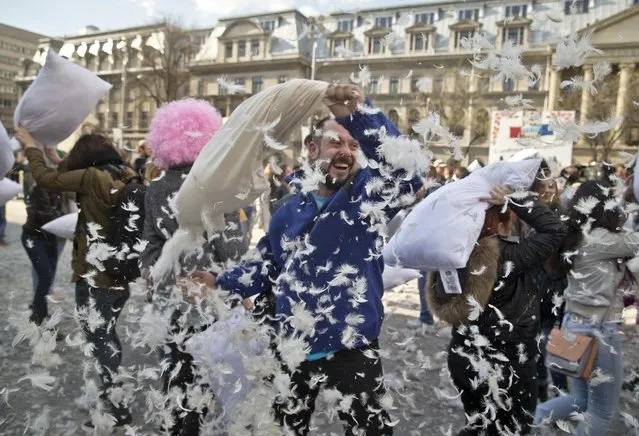 Feathers fly as people engage in a pillow fight downtown Bucharest, Romania, Saturday, April 4, 2015. (Photo by Vadim Ghirda/AP Photo)