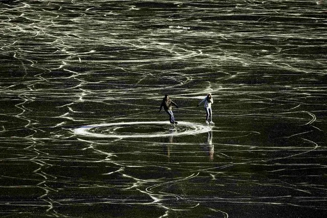 A couple skates on the frozen waters of Lake St. Moritz during a sunny winter day in the Swiss mountain resort of St. Moritz, on December 14, 2013. (Photo by Arnd Wiegmann/Reuters)