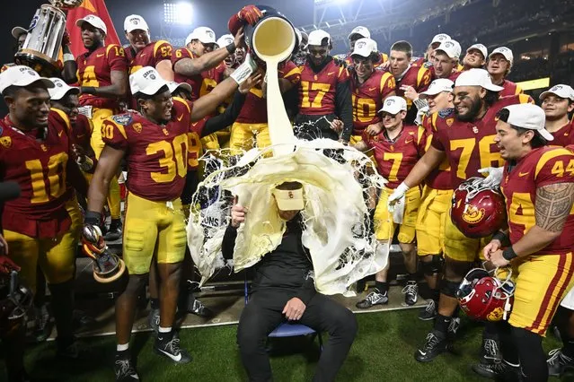 Southern California players pour eggnog onto coach Lincoln Riley after the team's 42-28 win over Louisville in the Holiday Bowl NCAA college football game Wednesday, December 27, 2023, in San Diego. (Photo by Denis Poroy/AP Photo)