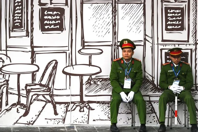 Vietnamese policemen sit on stools near the Sofitel Legend Metropole hotel in Hanoi on February 27, 2019, ahead of the second US-North Korea summit. US President Donald Trump touted North Korea's “AWESOME” future if his “friend” Kim Jong Un, whom he meets for a high-stakes dinner later on February 27, agrees to give up his nuclear arsenal. (Photo by Ye Aung Thu/AFP Photo)