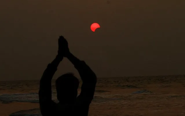 An Indian fisherman prays to a partial solar eclipse seen in the sky over Bay of Bengal in Konark, 60 kilometers (37 miles) from eastern Indian city Bhubaneswar, India, Wednesday, March 9, 2016. (Photo by Biswaranjan Rout/AP Photo)