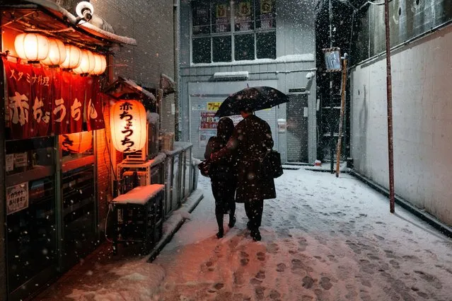 People are walking with umbrellas on a snow-covered street during the first snowfall of the year in Tokyo, Japan, on February 5, 2024. (Photo by Jerome Gilles/NurPhoto/Rex Features/Shutterstock)