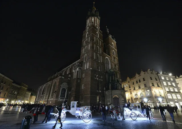 Lights are off for the global Earth Hour at the 14th-century red brick St. Mary's Basilica in the southern Renaissance city of Krakow, Poland, Saturday, March 30, 2019. The Earth Hour gesture calls for greater awareness and more sparing use of resources, especially fossil fuels. (Photo by Czarek Sokolowski/AP Photo)