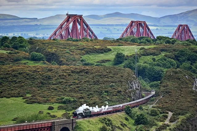 The Flying Scotsman steam train travels across the Forth Bridge, as it makes a journey through Fife on June 25, 2021 in Edinburgh, Scotland. The train will spend two days in Edinburgh where passengers will take a journey over the Forth Bridge in 1960's open carriages with large picture windows. (Photo by Jeff J. Mitchell/Getty Images)