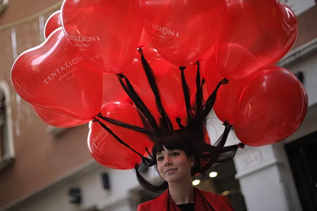 A woman's hair is held up by floating balloons as revellers dressed in masks and period costume take part at the Venice Carnival on February 12, 2017 in Venice. (Photo by Marco Bertorello/AFP Photo)