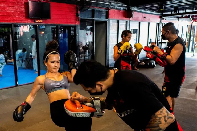 A woman practices Muay Thai inside a fitness gym after it reopened as part of a relaxation of coronavirus disease (COVID-19) restrictions in Bangkok, Thailand, October 2, 2021. (Photo by Athit Perawongmetha/Reuters)