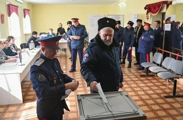 Cossacks vote at a polling station on the second day of a three-day long presidential election in the settlement of Krasny Kolos in Rostov Region, Russia on March 16, 2024. (Photo by Sergey Pivovarov/Reuters)