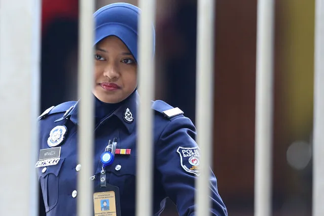 A police officer looks on as she stands at the gate of the morgue at Kuala Lumpur General Hospital where Kim Jong Nam's body is held for autopsy in Malaysia February 19, 2017. (Photo by Athit Perawongmetha/Reuters)