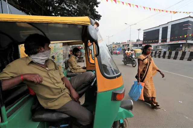 An auto rickshaw driver with his face covered as a precaution against COVID-19 waits for passengers in Bengaluru, capital of the southern Indian state  of Karnataka, Thursday, December 2, 2021. (Photo by Aijaz Rahi/AP Photo)
