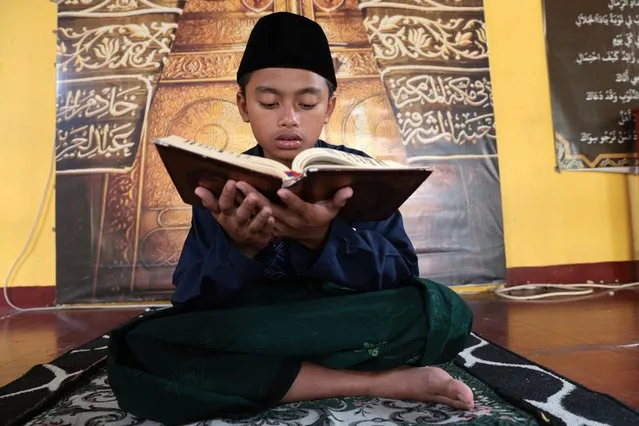 A student reads the Koran before breaking fast during the holy month of Ramadan at an Islamic boarding school in Depok, Indonesia, 13 March 2024. (Photo by Adi Weda/EPA/EFE)