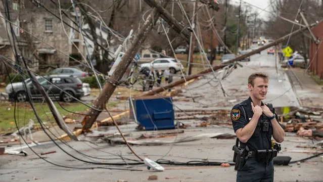 Police Officer Jamison McFall stands in the street on Saturday amid destruction left behind from tornadoes that swept through Bowling Green, Ky. on Saturday, December 11, 2021. (Photo by Austin Anthony/The Washington Post)