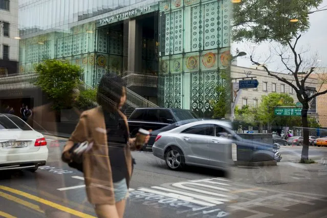 A woman is reflected in a window in the fashion district of Apgujeong in Seoul, May 7, 2015. (Photo by Thomas Peter/Reuters)