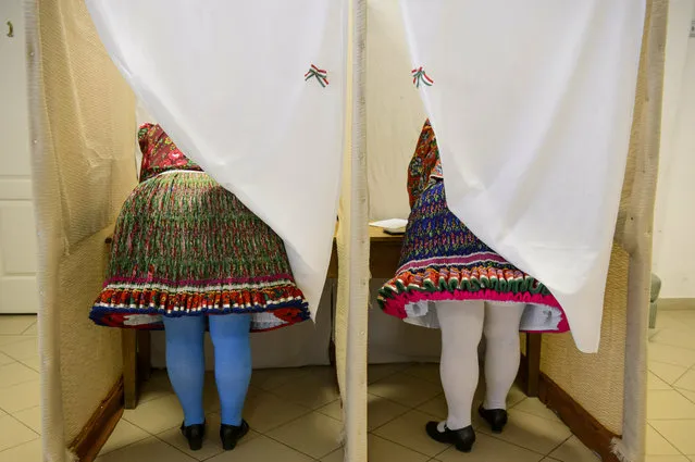 Women wearing folk costumes cast their vote during the European elections in a polling station in Bujak, Hungary, Sunday, May 26, 2019. The European Parliament election is held by member countries of the European Union (EU) from May 23 to 26, 2019. (Photo by Peter Komka/MTI via AP Photo)