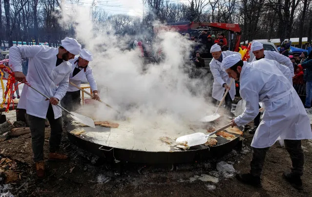Bakers make a pancake during celebrations of Maslenitsa, or Pancake Week, a pagan holiday marking the end of winter, in southern city of Stavropol, Russia, February 26, 2017. (Photo by Eduard Korniyenko/Reuters)