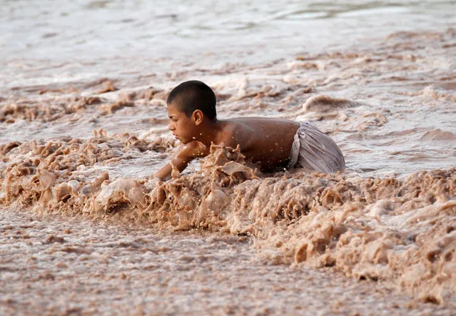 An Afghan boy swims in the muddy waters in Jalalabad province Afghanistan April 10, 2019. (Photo by Reuters/Parwiz)