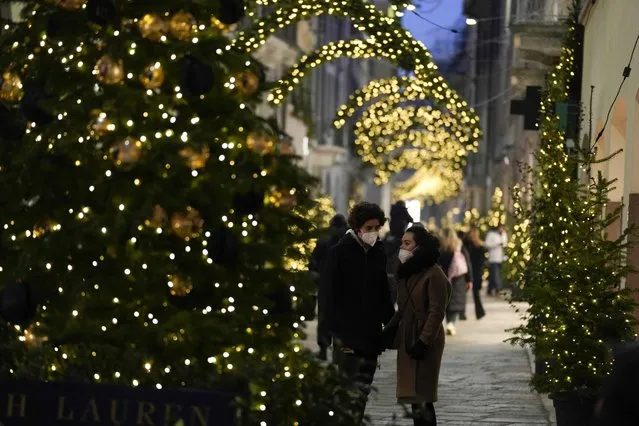 Pedestrian stroll along Via Montenapoleone fashion district decorated with seasonal lights, in Milan, Italy, Thursday, December 23, 2021. The Italian government is weighing possible outdoor mask mandates, increased testing and other measures to combat the new surge in infections fueled by the omicron variant. (Photo by Luca Bruno/AP Photo)