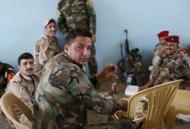 Iraqi soldiers have their lunch at their base in Makhmour, after it was freed from control of Islamic State, south of Mosul, April 17, 2016. (Photo by Ahmed Jadallah/Reuters)
