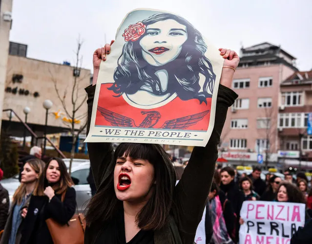 A woman holds a poster by US artist Shepard Ferey and reading “We the people, defend dignity” as Kosovo feminist supporters take part in a rally for gender equality and against violence towards women to mark the International Women's Day in Pristina on March 8, 2017. (Photo by Armend Nimani/AFP Photo)