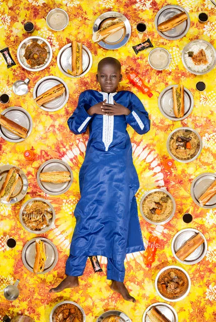 Photographer Gregg Segal travelled the world to document children and the food they eat in a week. Partly inspired by the increasing problems of childhood obesity, he tracked traditional regional diets as yet unaffected by globalisation, and ironically, found that the healthiest diets were often eaten by the least well off. Here: Meissa Ndiaye, 11, Dakar, Senegal, 2017. Ndiaye shares a single room with his dad, mum and brother in the heart of Parcelles Assainies, which means “sanitized plots”. A treeless, sandy suburb of Dakar, Parcelles Assainies was developed in the 1970s to house the poor overflowing from the city. Ndiaye, a devout Muslim and student at Quran School, loves sweet foods, such as a porridge, and goat meat, although in the week he kept a diary of his meals, he ate very little meat. (Photo by Gregg Segal/The Guardian)