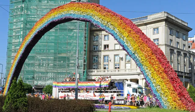 Marchers on a platform drive past a controversial art installation "The Rainbow"  during the annual gay pride parade in Warsaw, Poland, Saturday, June 13, 2015. Gay rights activists hold their 15th yearly "Equality Parade" as Poland slowly grows more accepting of gays and lesbians, but where gay marriage, and even legal partnerships, still appear to be a far-off dream. This year's parade comes amid a right-wing political shift, a possible setback for the LGBT community. (AP Photo/Alik Keplicz)