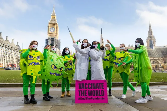 Activists from anti-poverty organisation, the ONE Campaign, wearing virus and medical costumes stage a protest calling for the sharing of coronavirus vaccines with developing countries in Parliament Square in London, Britain, 18 January 2022. (Photo by Vickie Flores/EPA/EFE)
