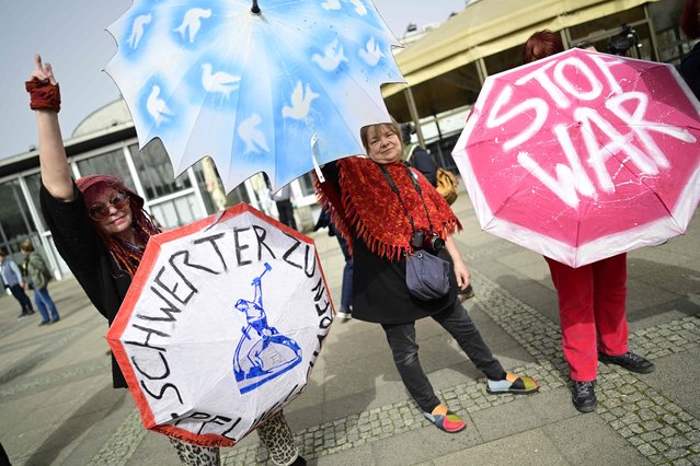 Demonstrators pose with colourful umbrellas featuring peace signs and reading “Stop war” as they participate in the Easter march peace demonstration along the Karl-Marx-Avenue in Berlin, on March 30, 2024. Numerous largetraditional Easter marches take place throughout Germany to protest against war. (Photo by John MacDougall/AFP Photo)