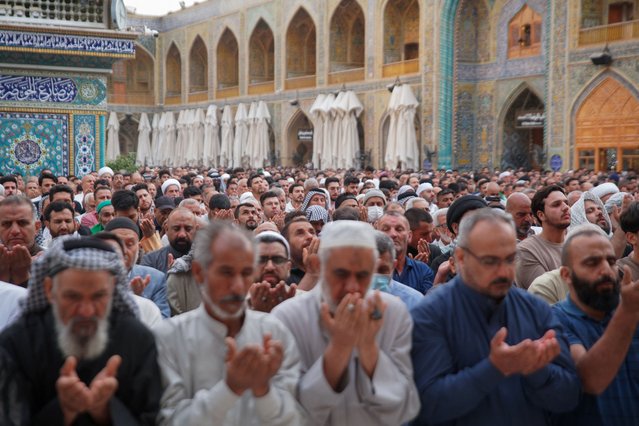 Muslim worshippers perform morning prayers to start Eid al-Fitr celebrations which mark the end of the holy fasting month of Ramadan, at the Imam Ali shrine in Iraq's Najaf city on April 10, 2024. (Photo by Qassem al-Kaabi/AFP Photo)