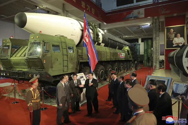 In this photo provided by the North Korean government, North Korean leader Kim Jong Un, center, speaks in front of what the North says an intercontinental ballistic missile displayed at an exhibition of weapons systems in Pyongyang, North Korea, Monday, October 11, 2021. Kim reviewed the rare exhibition and vowed to build an “invincible” military, as he accused the United States of creating regional tensions and lacking action to prove it has no hostile intent toward the North, state media reported Tuesday. Independent journalists were not given access to cover the event depicted in this image distributed by the North Korean government. The content of this image is as provided and cannot be independently verified. Korean language watermark on image as provided by source reads: “KCNA” which is the abbreviation for Korean Central News Agency. (Photo by Korean Central News Agency/Korea News Service via AP Photo)