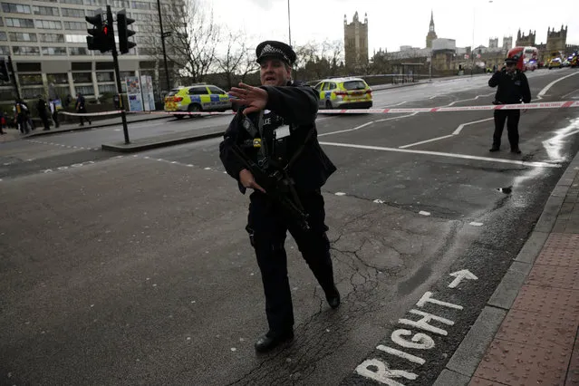 Police secure the area close to the Houses of Parliament in London, Wednesday, March 22, 2017. The leader of Britain's House of Commons says a man has been shot by police at Parliament. David Liddington also said there were “reports of further violent incidents in the vicinity”. London's police said officers had been called to a firearms incident on Westminster Bridge, near the parliament. Britain's MI5 says it is too early to say if the incident is terror-related. (Photo by Matt Dunham/AP Photo)