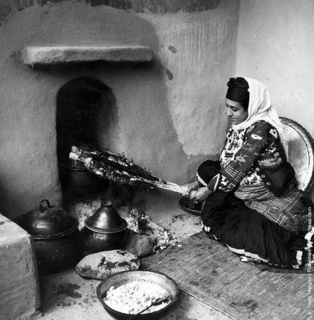 1950:  A peasant woman roasts a joint of meat in the Muslim manner, in the Mazanderan province of northern Iran