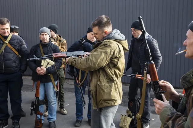 Civilian Members of a territorial defence unit fit their weapons to repel the Russian attacking forces in Kyiv, Ukraine, Saturday, February 26, 2022. Russian troops stormed toward Ukraine's capital Saturday, and street fighting broke out as city officials urged residents to take shelter. (Photo by Mikhail Palinchak/AP Photo)