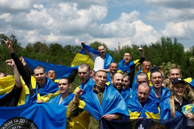 Ukrainian prisoners of war (POWs) shout slogans while they pose for a picture after a swap, amid Russia's attack on Ukraine, at an unknown location in Ukraine on May 31, 2024. (Photo by Valentyn Ogirenko/Reuters)