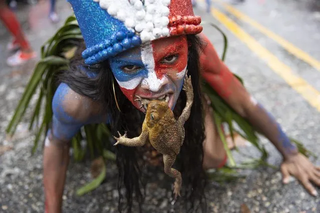 A member of a dance group puts a toad inside her mouth as she takes part in the 2022 National Carnival Parade, on the Malecon of Santo Domingo, Dominican Republic, 06 March 2022. The first post-pandemic national parade of the Dominican carnival had to appeal this Sunday to its color, enthusiasm and creativity to overcome the inclement rains that delayed and hindered the most popular and unbridled cultural display in the country. (Photo by Orlando Barria/EPA/EFE)