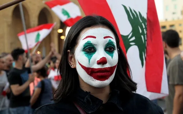 A lebanese girl paint her face with Lebanes flag color where Protesters wave Lebanese flags shout anti-government slogans during a protest in downtown Beirut, Lebanon, 19 October 2019. Hundreds of thousands of Lebanese families and youth from civil activists demonstrate in downtown Beirut condemning the proposed taxes that would go along with the 2020 budget, and shout slogan “The people want to bring down the government and parliament, and return the looted money”. (Photo by Nabil Mounzer/EPA/EFE/Rex Features/Shutterstock)