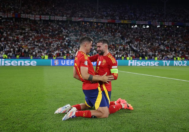 Álvaro Morata, left, and Dani Carvajal celebrate after Spain defeated England 2-1 to win its record-breaking fourth European Championship on Sunday, July 14, 2024. (Photo by Alex Pantling/UEFA/Getty Images)