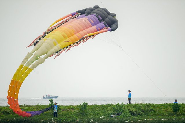 Participants fly their kite during the Jakarta International Kite Festival at Ancol Beach in Jakarta on July 4, 202 (Photo by Bay Ismoyo/AFP Photo)