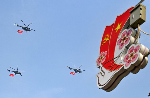 Helicopters with Vietnamese and Communist flags fly above Dien Bien Phu city on May 5, 2024, as Vietnam prepares to commemorate the 70th anniversary of the victory against French colonial forces. (Photo by Nhac Nguyen/AFP Photo)